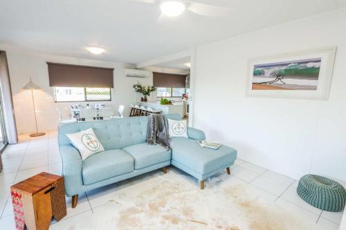a living room with a blue couch and a table at A Lure - 100m to Main Beach in Agnes Water