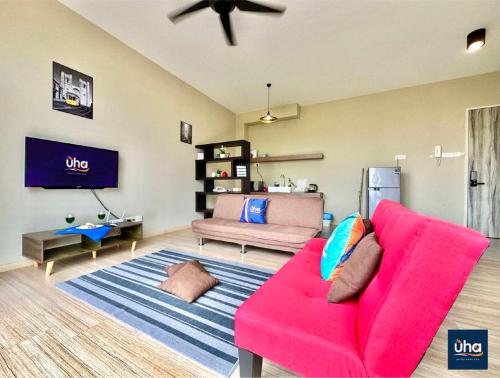 a living room with a pink couch and a tv at Austin Cube 8 Teens by RR JBcity in Johor Bahru