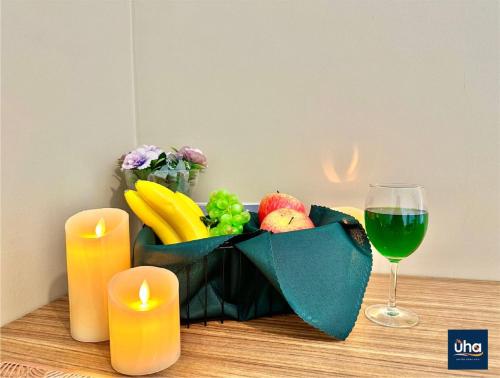 a table with candles and a bowl of fruit and a glass of wine at Austin Cube 8 Teens by RR JBcity in Johor Bahru