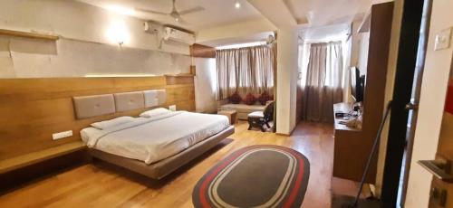 a bedroom with a bed and a living room at Aqua City Hotel in Panjim in Panaji