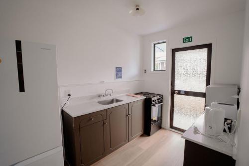 a kitchen with a sink and a stove at 301 Bealey Ave Motel Very Close to City Centre and Hagley park in Christchurch