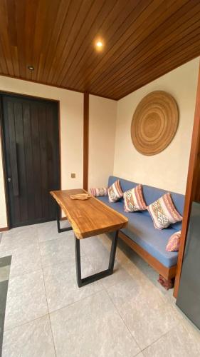 a room with a blue couch and a wooden table at Blue Calm Villas Bali in Tumbak Bayuh