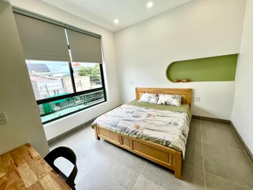 a bedroom with a bed and a large window at Luan Hoa Homestay in Ấp Bình Hưng