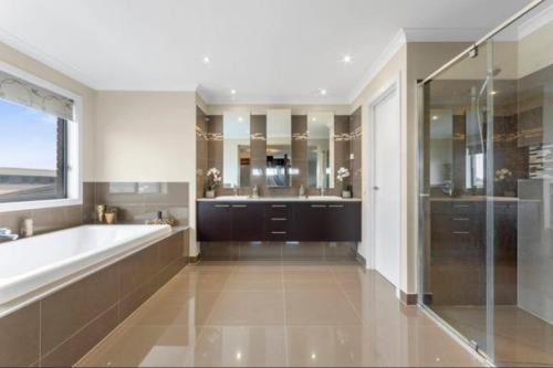 a large bathroom with a tub and a shower at Cozy family home near suft coast 6 beds in Grovedale