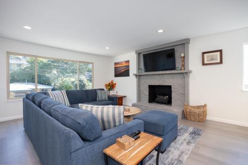 a living room with a blue couch and a fireplace at Cozy 3-bedroom house, ocean view, walk to beach! in El Granada
