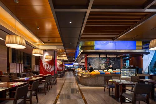 a restaurant with tables and chairs and a buffet at Sheraton Wenzhou Hotel in Wenzhou