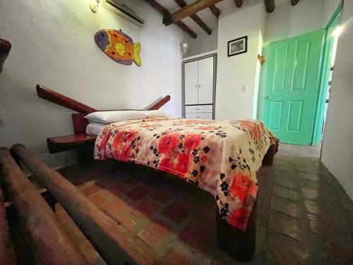 a bedroom with a bed and a green door at Posada Luisa Del Valle Guacuco in Playa Guacuco