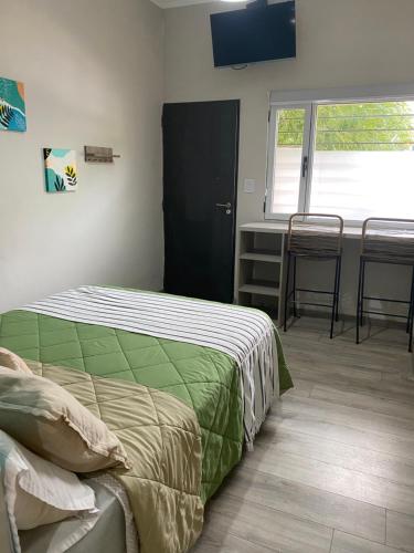 a bedroom with a bed and a desk and a window at Departamentos Pura Vida in General Roca