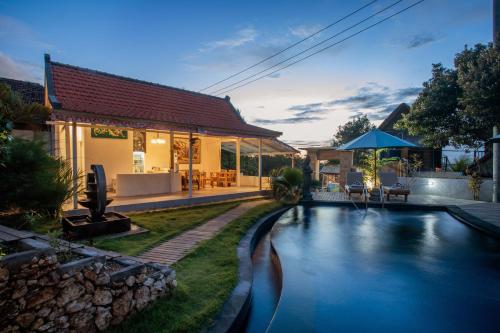a house with a swimming pool in front of a house at Blue Sky Villa Ceningan in Nusa Lembongan