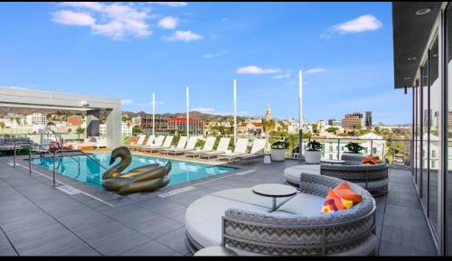 a rooftop patio with a swimming pool and lounge chairs at A-Class Highland 2 Bed Apt in Hollywood CA with FREE PARKING in Los Angeles