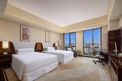 two beds in a hotel room with large windows at Sheraton Wenzhou Hotel in Wenzhou