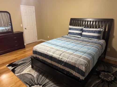a bedroom with a bed with blue and white sheets and a mirror at La Vergne hottub hospital mancave 75in Tv in La Vergne