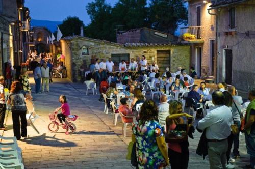 a crowd of people sitting in chairs in a street at Umbria nel cuore in Cannara