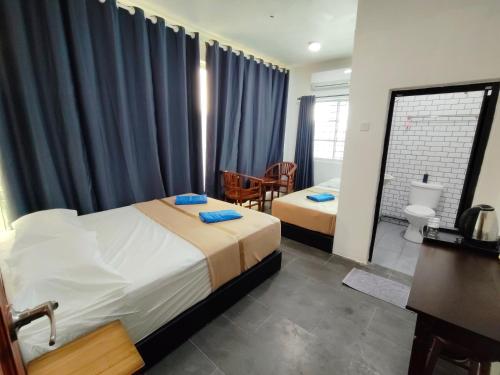 a hotel room with two beds and a bathroom at Perhentian Najmi Hotel in Perhentian Island