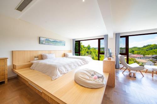a bedroom with a large bed with a large window at Anji Bamboo Homestay in Tangkou