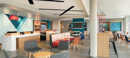 a lobby with chairs and tables and a cafeteria at avid hotel Lexington - Hamburg Area by IHG in Lexington