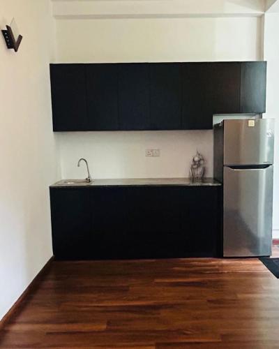 a kitchen with a sink and a refrigerator at Rasika Villa in Sri Jayewardenepura Kotte