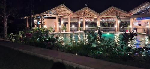 a swimming pool in front of a building at night at Annabel's Resort in Ferrol
