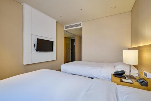 a hotel room with two beds and a television at Summit Hotel Seoul Dongdaemun in Seoul
