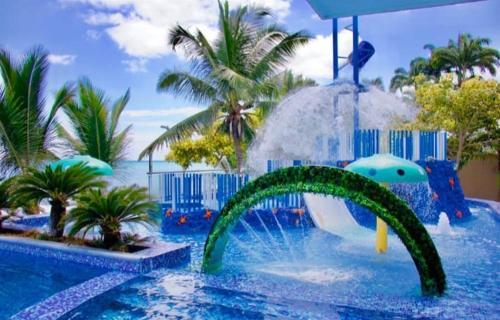 a water slide in a pool at a resort at GRAND DIAMOND BEACH Tonsupa Atacames in Tonsupa
