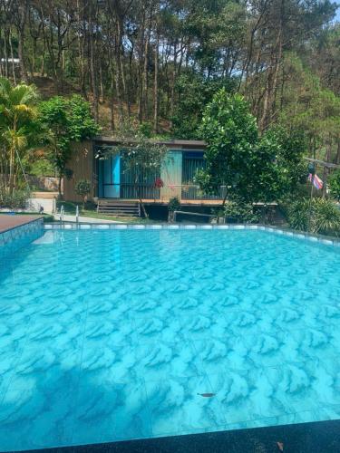 a large swimming pool with blue water at SH Homestay - Venuestay in Sóc Sơn