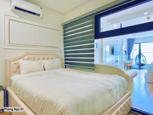 a bedroom with a large bed and a window at TYE APARTMENT - TMS Pullman Quy Nhơn in Quy Nhon