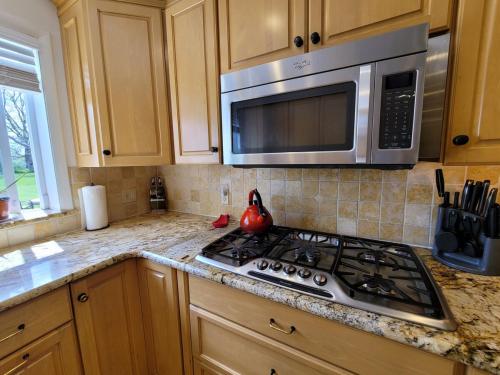 a kitchen with a stove and a microwave at Bridle Pool House in Lansdale