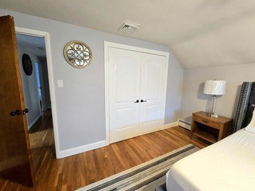a bedroom with a white door and a wooden floor at Bridle Pool House in Lansdale