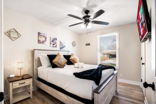 ein Schlafzimmer mit einem Bett mit Deckenventilator in der Unterkunft Serenity Cottage 300mbps Wifi - Dog Friendly in Clarksville