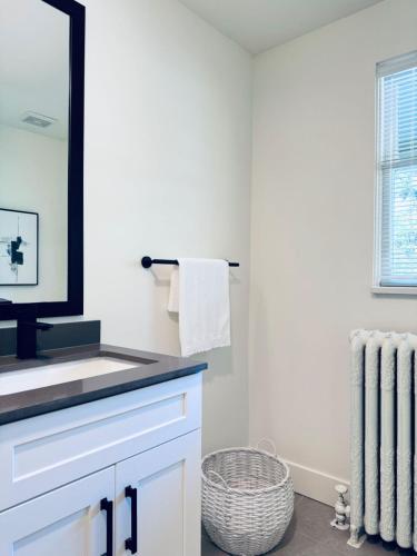 a bathroom with a sink and a mirror at Deluxe Queen Room Private Ensuite Vancouver West in Vancouver