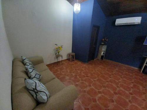 a living room with a couch and a blue wall at Palmerola Inn in Villa de San Antonio