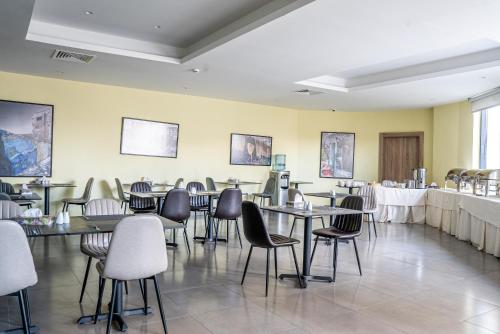a restaurant with tables and chairs in a room at Liv Weibdeh Hotel Suites in Amman