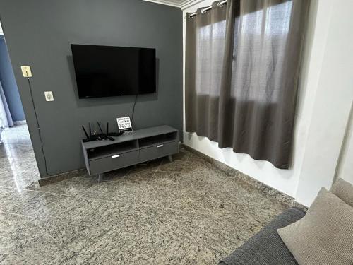 a living room with a flat screen tv on a wall at Cobertura de Frente Para o Mar e Piscina Village das Ondas in Piúma