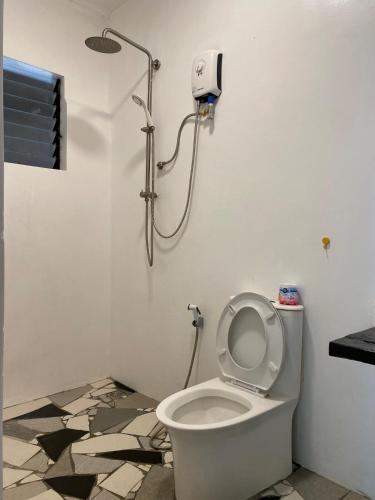 a bathroom with a toilet with a shower at Big Fun Beach House in Bacong