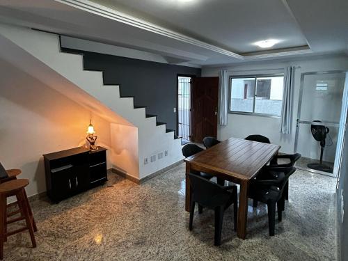 a dining room with a table and a staircase at Cobertura de Frente Para o Mar e Piscina Village das Ondas in Piúma