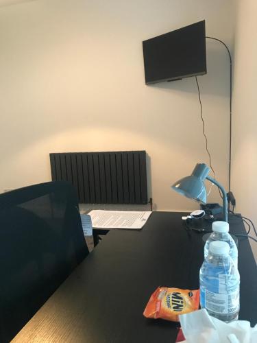 a desk with a lamp and a bottle of water on it at Harcourt Road in Nottingham