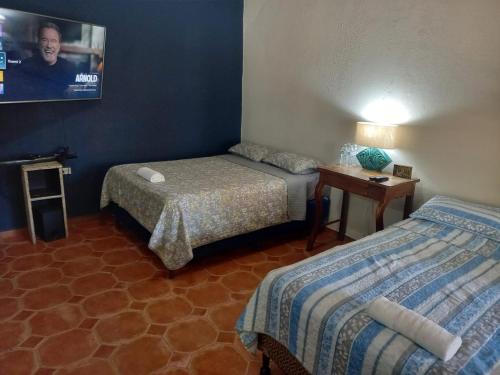 a hotel room with two beds and a table at Palmerola Inn in Villa de San Antonio