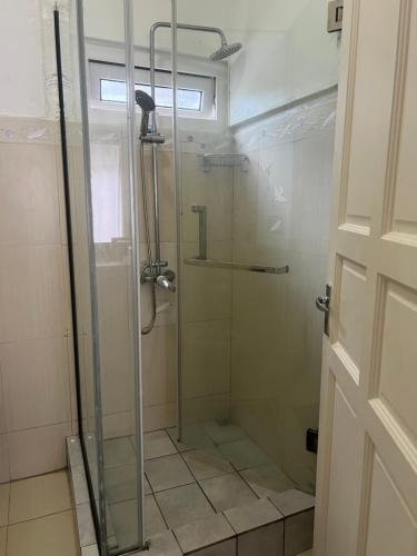 a bathroom with a shower with a glass door at Oceanpride Complex in Flic-en-Flac