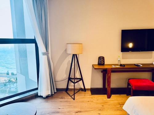 a room with a television and a table with a lamp at Mũi Né Luxury- View sea Apec in Ấp Thiẹn Ái