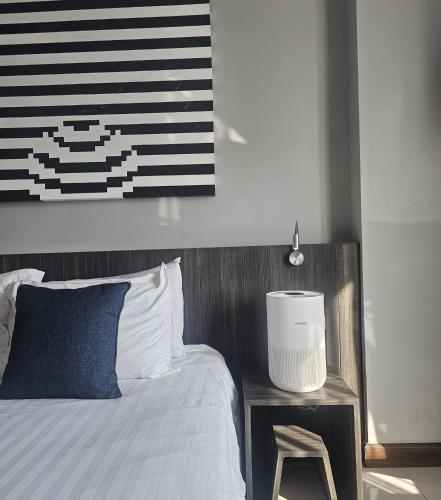 a bedroom with a bed and a table with a stool at Art Mai Gallery Nimman Hotel Chiang Mai in Chiang Mai