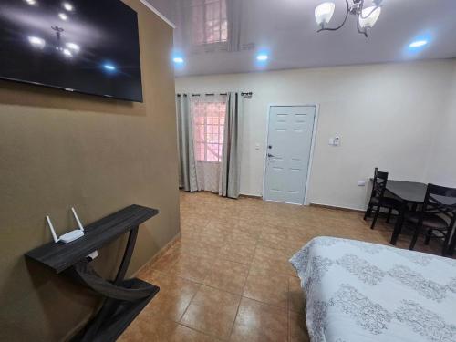 a living room with a table and a tv on the wall at Palmerola Inn in Villa de San Antonio