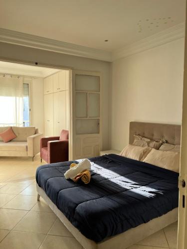 a bedroom with a bed and a living room at Maison azur in Tunis