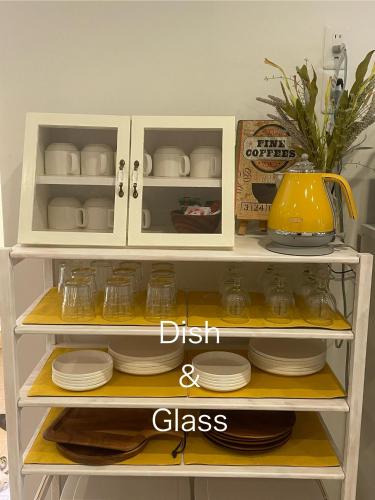 a white shelf with dishes and a pot on it at Yellow House Okinawa in Naha