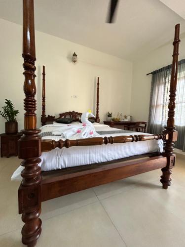 a bedroom with a large wooden bed in a room at Santa Maria - A Premium Boutique Homestay by the Sea I Trivandrum Airport 1mile in Trivandrum