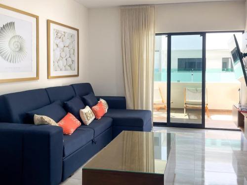a living room with a blue couch and a glass table at Charming apartment 3 minutes from the beach in Mazatlán