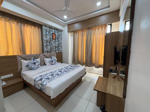 a bedroom with a bed and a television in it at Hotelsuncity inn in Vadodara