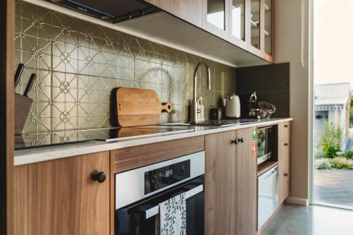 a kitchen with wooden cabinets and a stove top oven at Hollyberry House in Cooma