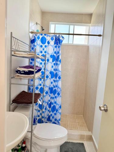 a bathroom with a blue shower curtain and a toilet at Villa Aqua-Alberca-Terraza- HiveNB in Tlayecac