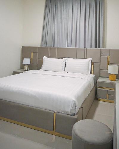 Un dormitorio con una cama grande con sábanas blancas. en الوادي - نسائم صلالة للشقق الفاخرة Nassayem Salalah Al-Wadi, en Salalah