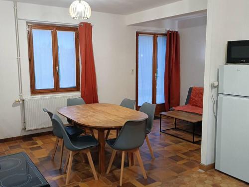 d'une salle à manger avec une table, des chaises et un réfrigérateur. dans l'établissement Gîte tranquille proche Forêt Orléans pour 5 pers. - FR-1-590-569, à Varennes-en-Gâtinais